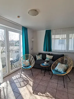 Wohnzimmer mit Schlafcouch 140 x 200 cm mit Blick auf den Balkon