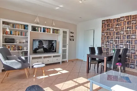 Wohnzimmer mit Esstisch, Sessel, und TV