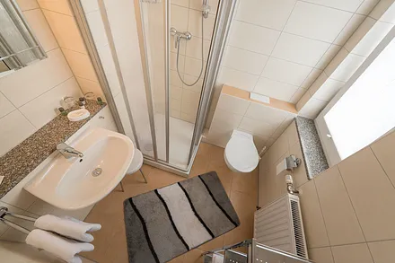 Badezimmer mit Dusche und WC, Fön