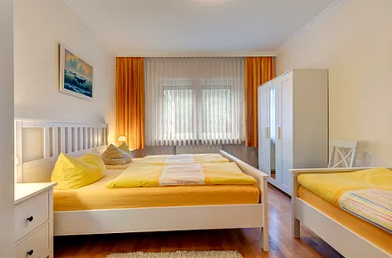 Schlafzimmer mit Doppel- und Einzelbett, 2 Kleiderschränke, Rolläden vor dem Fenster