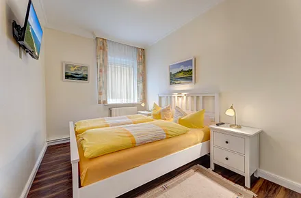 Schlafzimmer mit Doppelbett, Flat-TV, Jalousie vor dem Fenster