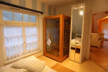 großes Wohnzimmer mit Ledermöbeln und  Küchenzeile