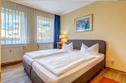 Schlafzimmer mit Boxspingbett und Flat-TV