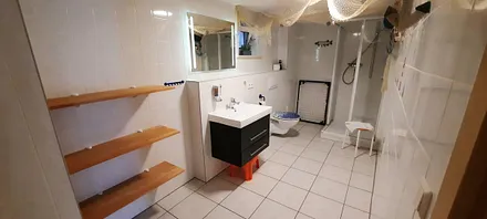 Das große Badzimmer ist mit einer flachen Einstiegsdusche ausgestattet. 