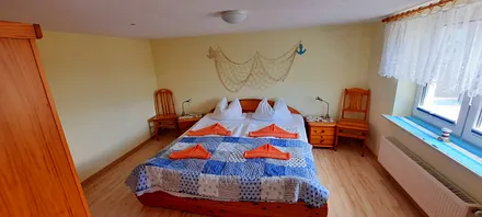 Schlafzimmer mit Doppelbett und großem Kleiderschrank.