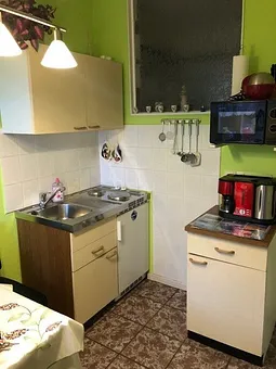 Jetzt befinden wir uns in der Küche. Zusehen ist die Sitzecke sowie die Spüle und die Kochstelle. Die Tür gerade zu geht ins Bad und die Tür rechte Seite führt in den Wohn/Schlafbereich.