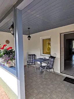 Von der überdachten Terrasse gelangt in die Küche mit Essbereich