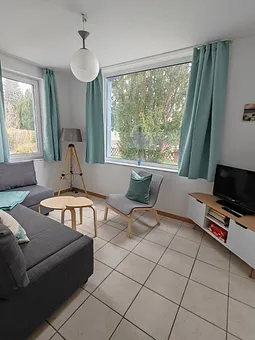 Die Couch lässt sich mit einfachen Handgriffen in eine Schlafgelegenheit oder Lümmlecke verwandeln. Neben dem Fernseher gibt es eine Auswahl an Büchern für Groß und Klein und Spielesammlung