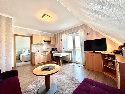 Wohnzimmer mit Balkon und Wohnküche