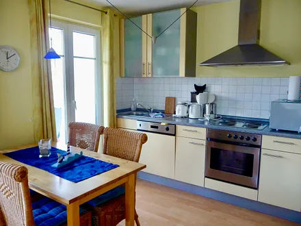 Küchenzeile mit Esstisch und Zugang zum Balkon