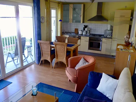 Wohnzimmer mit offener Küche und Zugang zum Balkon I