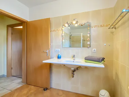 Blick in das Bad mit dem großen Waschtisch. 