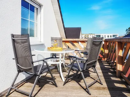Blick auf den Balkon. Die entsprechenden Möbel und ein Sonnenschirm gehören im Sommer einfach dazu.