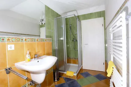 Blick in das farbenfrohe Bad mit Dusche