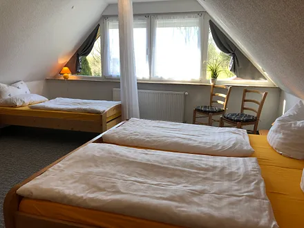 Schlafzimmer mit Blick in den Garten und Sichtschutz zu den Ehebetten