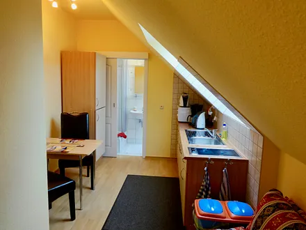 Separate Küche mit Schlafcouch für 1 Person, Ceranfeld (2 Felder), Kühlschrank mit Gefrierfach, Mikrowelle, Kaffeemaschine, Wasserkocher, Toaster und diversen Küchenutensilien.