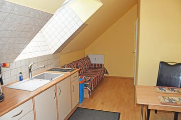 Separate Küche mit Schlafcouch für 1 Person, Ceranfeld (2 Felder), Kühlschrank mit Gefrierfach, Mikrowelle, Kaffeemaschine, Wasserkocher, Toaster und diversen Küchenutensilien.