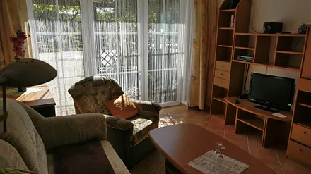 Wohnzimmer mit kl. Anbauwand Fernseher und Radio u. Küchenzeile 