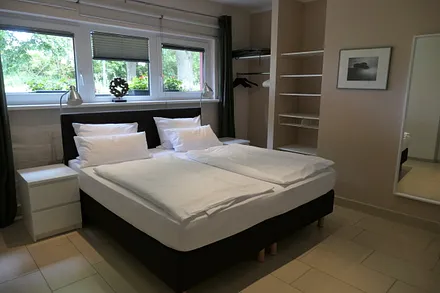 Schlafzimmer mit Hotelboxspringbett (1,80 x 2 m, Bandscheibenfederkernmatratze), integrierter offener Kleiderschrank, Kommode