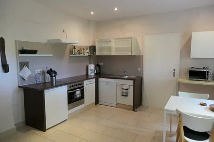 Küchenzeile ausgestattet mit Backofen, 4-Platten-Cerankochfeld, Kühlschrank mit Gefrierfach, Geschirrspülmaschine, Mikrowelle, Kaffemaschine, Wasserkocher und Toaster