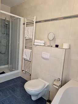 Das Badezimmer mit Badewanne und Dusche