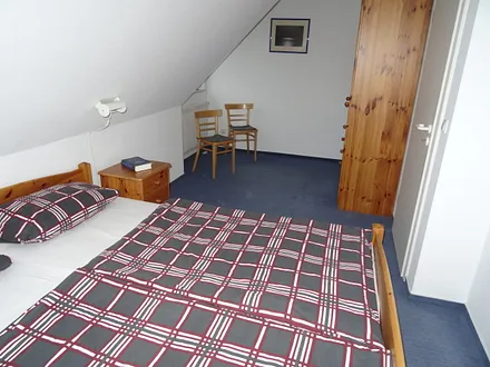 Schlafzimmer mit Doppelbett und Platz für Babybett