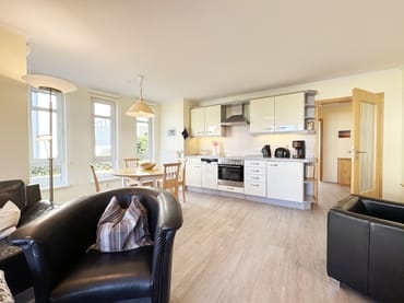 Wohnzimmer mit TV und Blick zur Küchenzeile