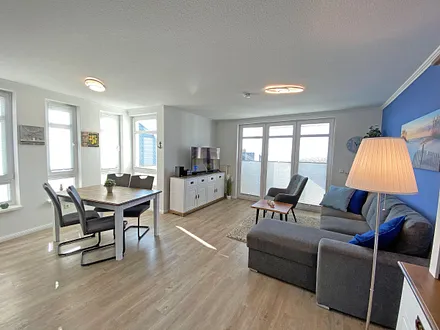 Wohnzimmer mit einem 2-Sitzer, Sessel, Vitrine, TV-Board, mit Smart TV und Ministereoanlage