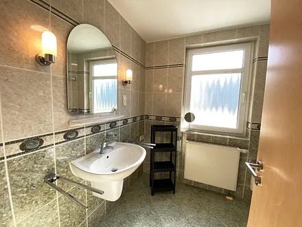 Badezimmer mit einer Dusche, WC, Kosmetikspiegel und Fön