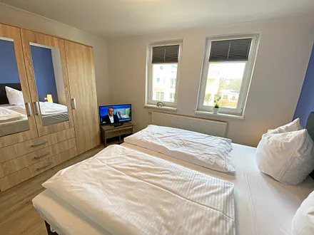 Schlafzimmer mit Boxspringbett (1,80 m x 2,00 m), Kleiderschrank, Nachttische, Sideboard sowie ein zweiter Smart-TV