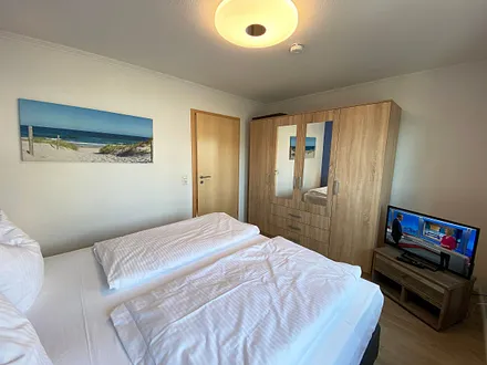 Schlafzimmer mit Boxspringbett (1,80 m x 2,00 m), Kleiderschrank, Nachttische, Sideboard sowie ein zweiter Smart-TV