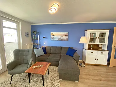 Wohnzimmer mit einem 2-Sitzer, Sessel, Vitrine, TV-Board, mit Smart TV und Ministereoanlage