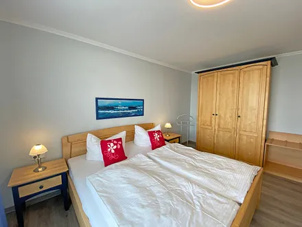 Schlafzimmer mit Doppelbett (1,80 m x 2,00 m), verstellbare Lattenroste, Kleiderschrank, Nachttischkonsolen und Verdunklungsvorhänge