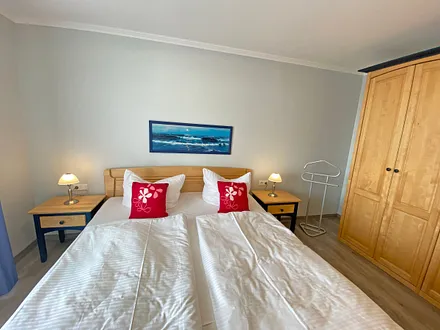 Schlafzimmer mit Doppelbett (1,80 m x 2,00 m), verstellbare Lattenroste, Kleiderschrank, Nachttischkonsolen und Verdunklungsvorhänge