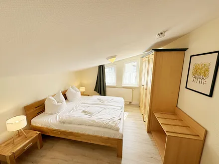 Schlafzimmer mit Doppelbett, Kleiderschrank, Nachttischkonsolen