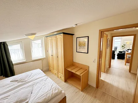 Schlafzimmer mit Doppelbett, Kleiderschrank, Nachttischkonsolen