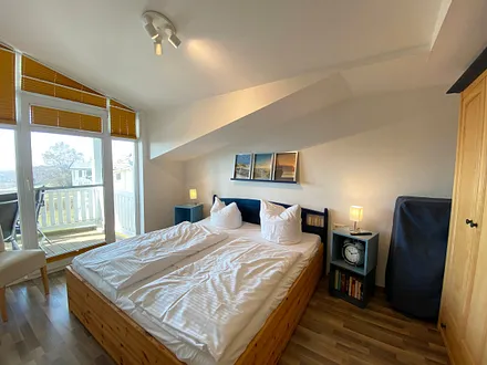 Schlafzimmer mit Doppelbett, Kleiderschrank, Nachttischkonsolen