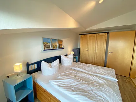 Schlafzimmer mit Doppelbett, Kleiderschrank, Nachttischkonsolen