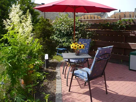 Terrasse mit Gartenmöbeln und Sonnenschirm