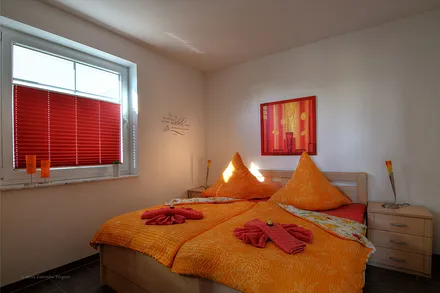 Schlafzimmer mit Doppelbett und großem Kleiderschrank. Die Erstausstattung mit Bettwäsche ist inklusive.