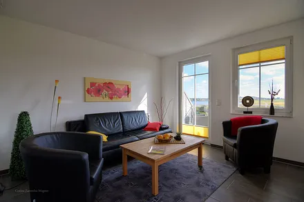Wohnzimmerecke mit Schlafcouch, Ausgang auf Ihren Balkon u. faszinierende Ausblicke auf den Zickersee, den Greifswalder Bodden und den alten Fischerhafen.