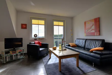 Wohnzimmerecke mit Schlafcouch, Ausgang auf Ihren Balkon, mit faszinierendem Ausblick auf den Zickersee, die Ostsee (Greifswalder Bodden) und den alten Fischerhafen.