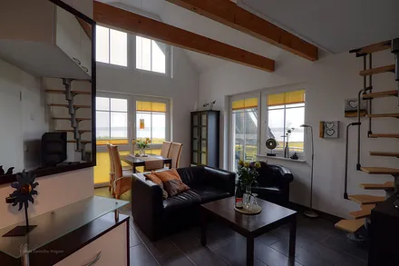 Wohnbereich mit Zugang zur offenen Schlafempore.