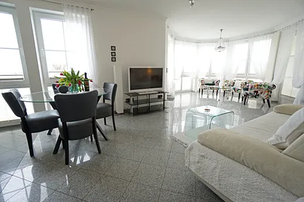 Wohnzimmer mit Schlafcouch und Flachbildfernseher