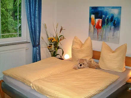 Blick in eines der beiden Schlafzimmer - beide mit Doppelbett (Parkett, getrennte Matratzen, Insektenschutzgitter) 