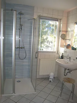 Blick in eines der beiden Bäder. Beide mit Fenster, nahezu ebenerdiger neuer Dusche, WC & Kosmetikspiegel, dieses hier zusätzlich mit Fön, das andere mit Münzwaschmaschine.