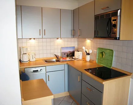 Blick in den gut ausgestatteten Küchenbereich mit Geschirrspüler, Mikrowelle & vielen E-Geräten