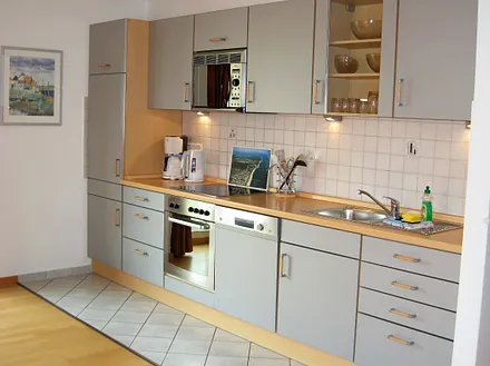 Blick auf den gut ausgestatteten Küchenbereich mit vielen E-Geräten, Geschirrspüler und Backofen.