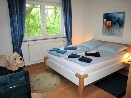 Blick in eines der beiden Schlafzimmer, beide mit Doppelbett (Laminat, getrennte Matratzen, Insektenschutzgitter )