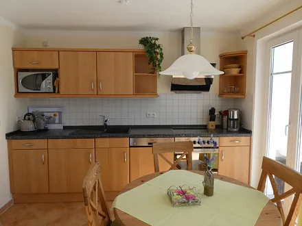 Wohnraum mit komplett ausgestatteter Küchenzeile